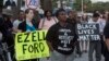 FILE - Protesters carry signs during a demonstration by Black Lives Matter in Los Angeles, August 11, 2015.