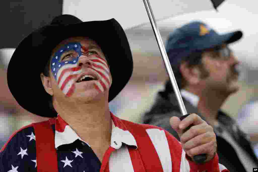 Matthew Usher looks up at the clouds to check for rain as he waits for a concert to start as part of the Independence Day activities, July 4, 2013, in Nashville, Tennessee.