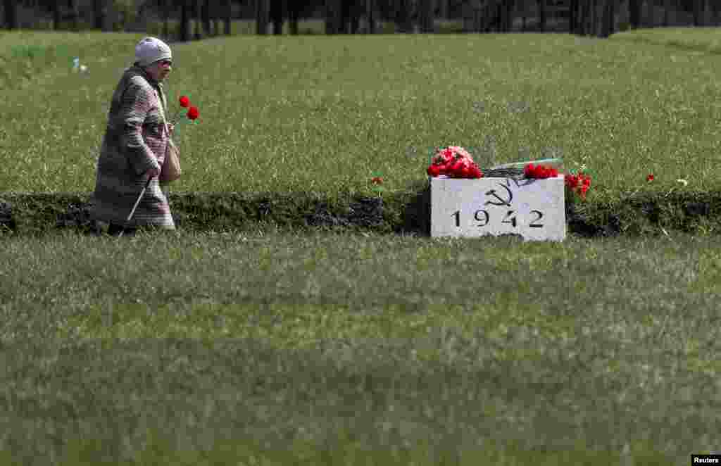 A woman carries flowers at the Piskaryovskoye Memorial Cemetery on the eve of Victory Day, marking the 74th anniversary of the victory over Nazi Germany in World War II, in Saint Petersburg, Russia.