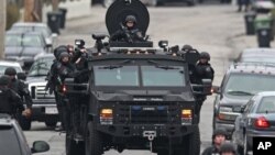 Police patrol through a neighborhood in Watertown, Mass., while searching for a suspect in the Boston Marathon bombings, April 19, 2013