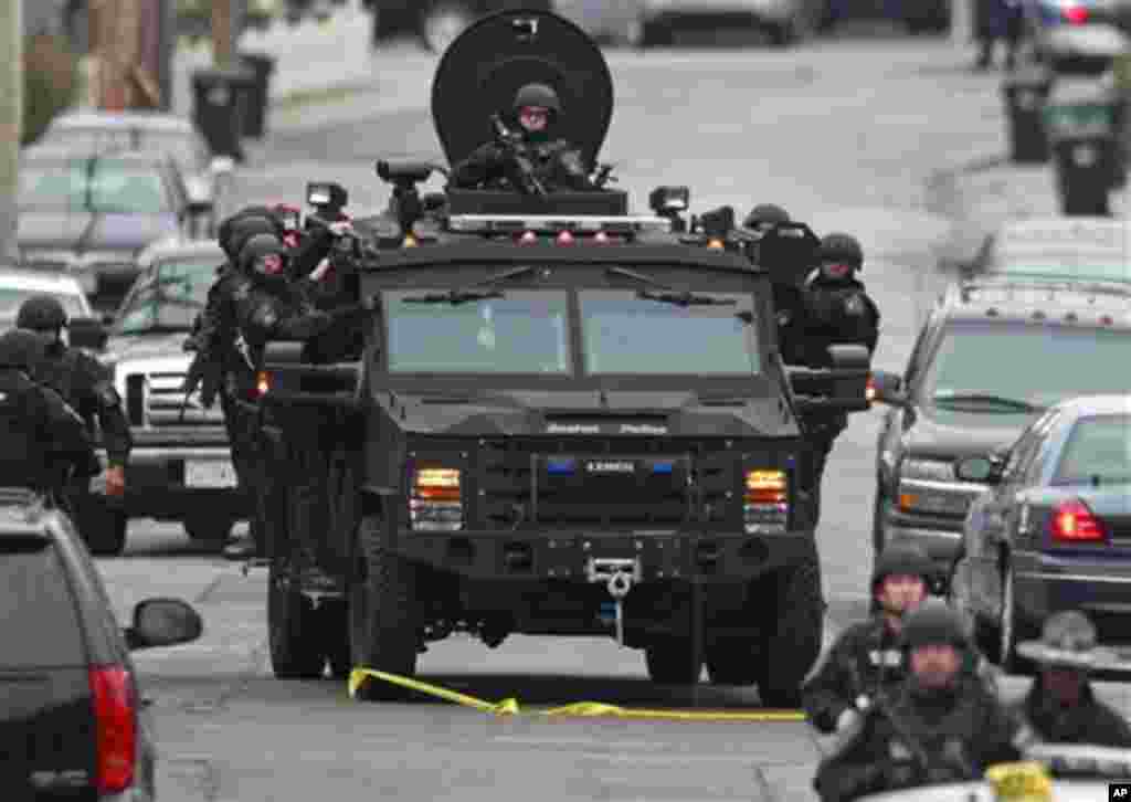 Police patrol through a neighborhood in Watertown, Mass., while searching for a suspect in the Boston Marathon bombings, April 19, 2013