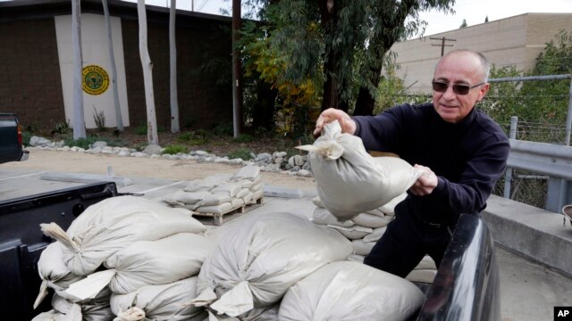 Frank Salazar, de Glendora, California, prepara bolsas de arena para proteger su vivienda de las posibles inundaciones que se prevén en los próximos días.