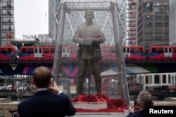 People look at a temporary sculpture installed to mark the centenary of the Armistice which ended the First World War, in the Canary Wharf financial district of London, Britain, Nov. 1, 2018.