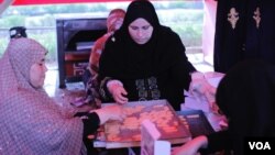 After the biscuits cool, women fill boxes which they distribute among protesters and neighbors that support their cause. (H. Elrasam/VOA)