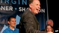 Foto de 2009, en que aparece el senador Creigh Deeds, durante un evento de campaña, con su hijo, Gus al fondo a la izquierda, en camisa celeste.