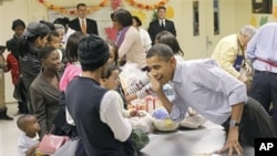 President Barack Obama, right, leans over to listens to hear child speak as he helps pack food for Thanksgiving at Martha's Table, a local food pantry in Washington, 24 Nov., 2010.