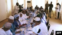 Mali's interim president, Dioncounda Traore (Back center R), speaks with ministers during a cabinet meeting at which a national state of emergency was declared, in Bamako, January 11, 2013.