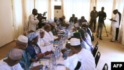 Mali's interim president, Dioncounda Traore (Back center R), speaks with ministers during a cabinet meeting at which a national state of emergency was declared, in Bamako, January 11, 2013.