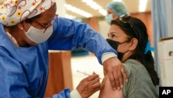 Una mujer venezolana recibe una tercera dosis de la vacuna Sinopharm contra el COVID-19 en Caracas el 3 de enero de 2022.