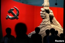 资料照：北京军事博物馆展示的中共党旗与一只握枪的手的雕塑
