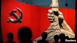 资料照：北京军事博物馆展示的中共党旗与一只握枪的手的雕塑。