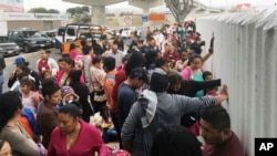 People seeking political asylum in the United States line up to be interviewed in Tijuana, Mexico, just across the U.S. border south of San Diego, June 4, 2018.