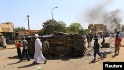 A police car flipped over and damaged by mourners near the home of a demonstrator who died of a gunshot wound sustained during anti-government protests in Khartoum, Sudan, Jan. 18, 2019.