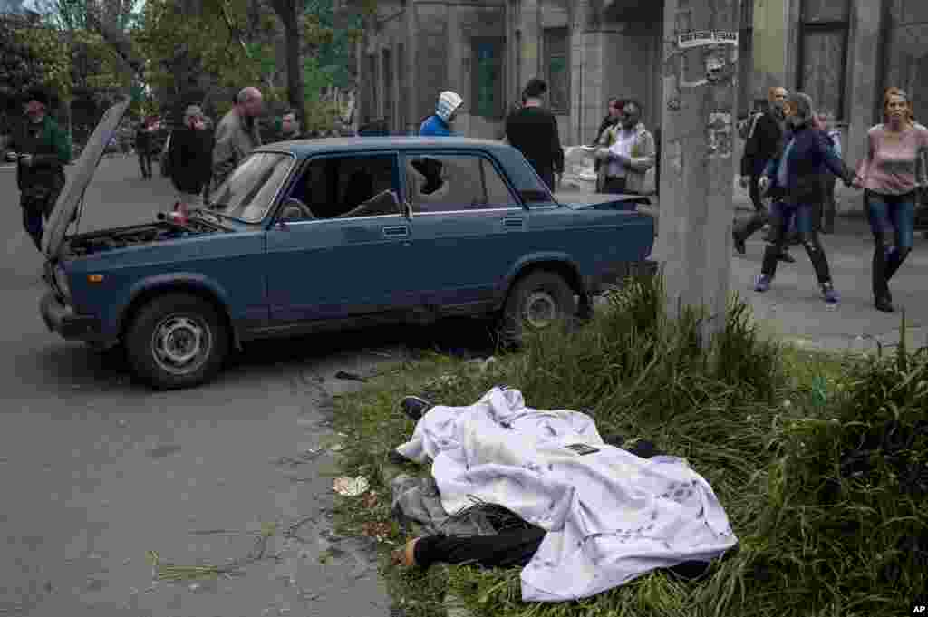 The body of a person killed in clashes lies outside a police station in Mariupol, eastern Ukraine, May 9, 2014.&nbsp;