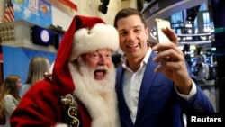 Tom Farley, president of the NYSE Group, poses for a selfie with Santa Claus, who rang the opening bell to celebrate the Macy's 90th Annual Thanksgiving Day Parade, at the New York Stock Exchange in New York City, Nov. 23, 2016. 