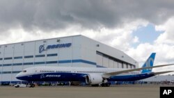 FILE - Boeing employees stand near the new Boeing 787-10 Dreamliner at the company's facility in South Carolina after conducting its first test flight at Charleston International Airport in North Charleston, S.C., March 31, 2017.