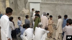 People gather outside the locked house of a Christian girl who was arrested in the suburbs of Islamabad, Aug. 20, 2012. 