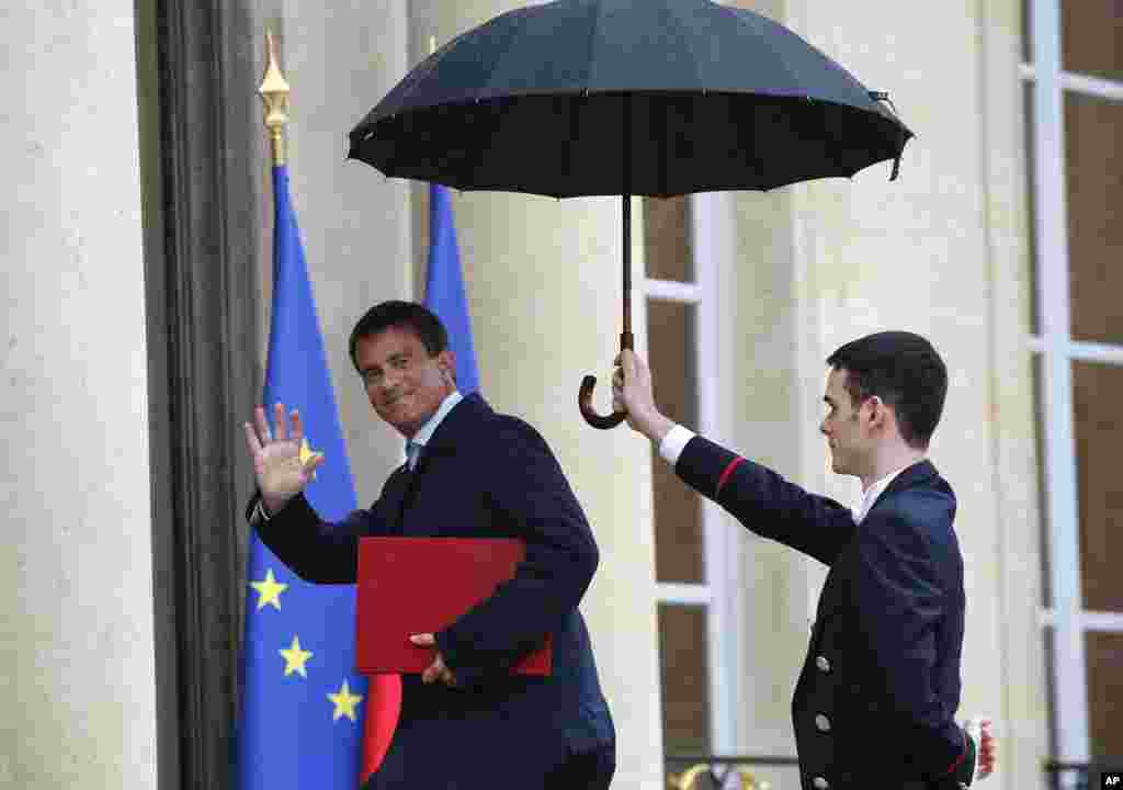 French Prime Minister Manuel Valls (left) waves as he arrives for a meeting with French President Francois Hollande at the Elysee Palace in Paris, Aug. 25, 2014.&nbsp;