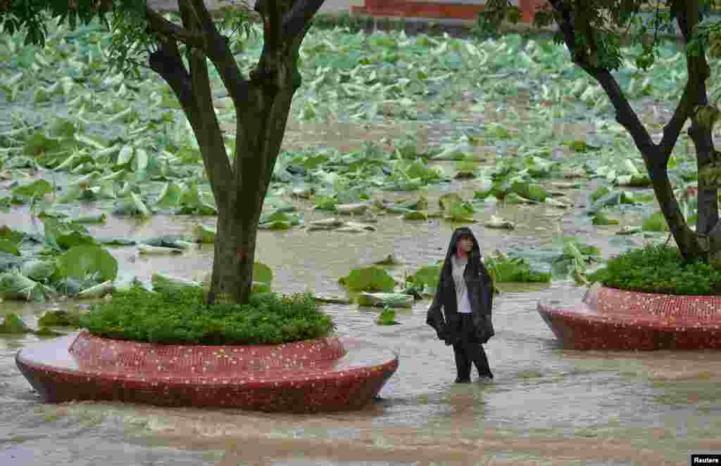 A boy stands on a flooded road amid heavy rainfall in Chengdu, Sichuan province, China, July 2, 2018.