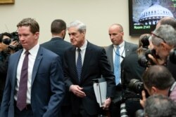 Escorted by a security detail, former special counsel Robert Mueller arrives to testify to the House Judiciary Committee about his investigation into President Donald Trump and Russian interference in the 2016 election, July 24, 2019.