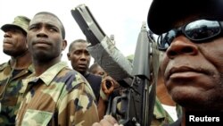 FILE - Guy Philippe, former police chief police, participates in a march into the city of Gonaives, Haiti, Feb. 19, 2004.