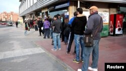 People queue outside a government-run job centre in Madrid, Spain, April 27, 2016. 