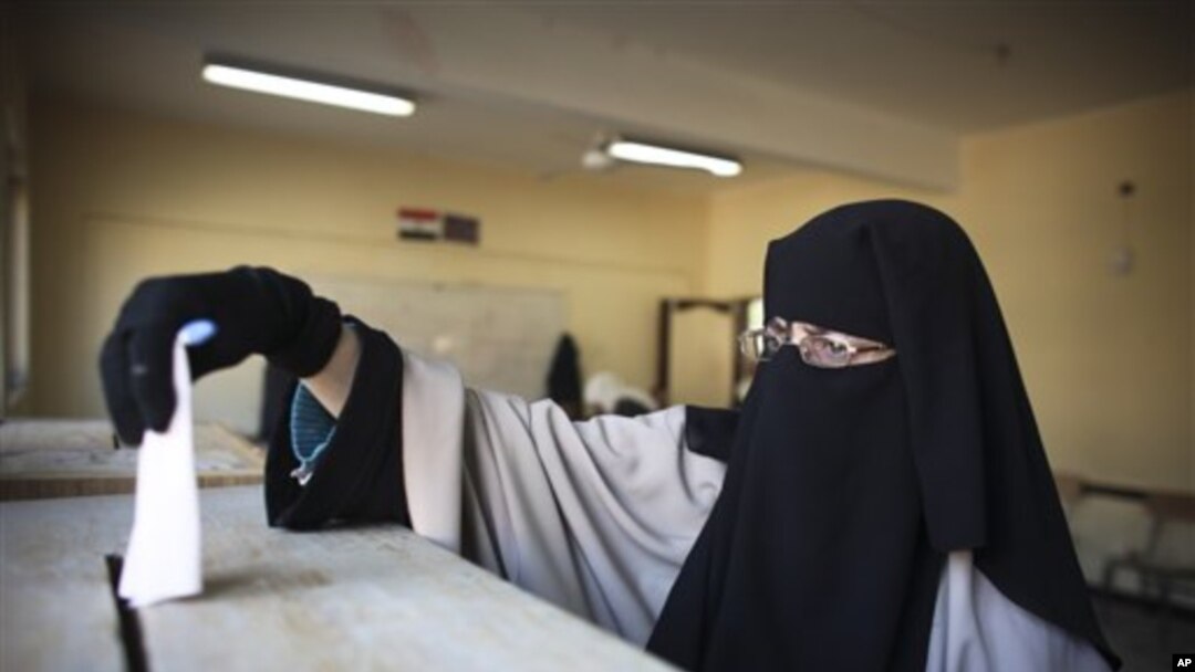 Matar Misra cikin Hijabi ke kokarin jefa kuri'a a birnin Alkahira a zaben ranar litinin.