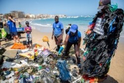 Volunteers sort rubbish found under water and along the beach during an underwater cleanup for Earth Day in Dakar, Apr. 23, 2021.