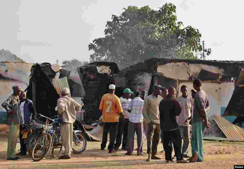 Mahalliy aholi vakillari Mpeketonida jangarilar vayron qilgan binolarni ko&#39;zdan kechirmoqda, 16-iyun, 2014-yil.