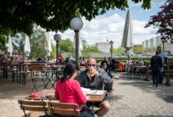 A guest enjoys his beer at a beer garden near the Chancellery in Berlin, Germany, May 21, 2021, as parts of the country began easing COVID-19 restrictions.