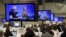 US Democratic presidential candidates Hillary Clinton and Bernie Sanders appear on television screens in the media work-room during the Democratic presidential candidates debate.