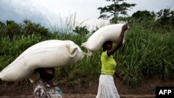 Des femmes congolaises portent des sacs de nourriture sur leurs têtes lors d'une distribution de nourriture à Kasala, dans la région agitée du Kasaï, RDC, 25 octobre 2017. 