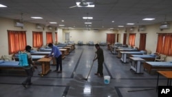 Indian workers disinfect an isolation center for COVID-19 positive people in Hyderabad, India, May 3, 2021.