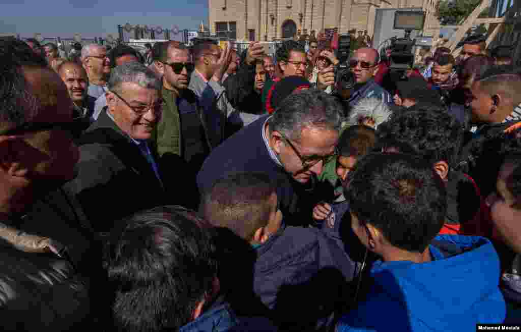 Dr. Khaled ElAnany, Minister of Tourism and Antiquities, listens to school children telling what they learned from their tour of the Virgin Mary Church. (Hamada Elrasam/VOA)