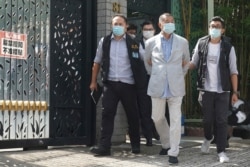 Hong Kong media tycoon Jimmy Lai, center, who founded local newspaper Apple Daily, is arrested under the new national security law by police officers, Aug. 10, 2020.