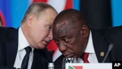 Russian President Vladimir Putin, left, speaks to South African President, Cyril Ramaphosa, during a plenary session at the Russia-Africa summit in the Black Sea resort of Sochi, Russia on Oct. 24, 2019