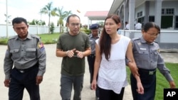 Singaporean journalist Lau Hon Meng, center left, and Malaysian journalist Mok Choy Lin, both accused of flying drones illegally over parliament buildings, are escorted at a court in Naypyitaw, Myanmar, Nov. 10, 2017.