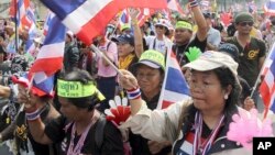 Anti-government protesters wave flags as they march on the street during a warm-up rally to paralyze the capital Tuesday, Jan. 7, 2014 in Bangkok, Thailand.
