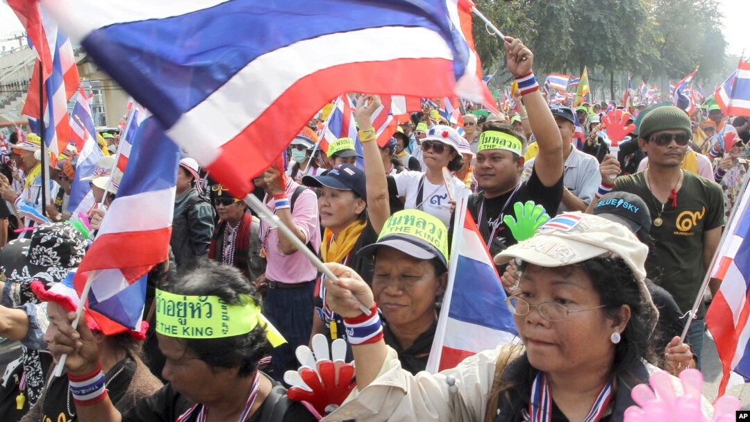 Demontran anti-pemerintah mengibarkan bendera Thailand sambil berpawai memadati jalanan ibukota Thailand, Bangkok (7/1).