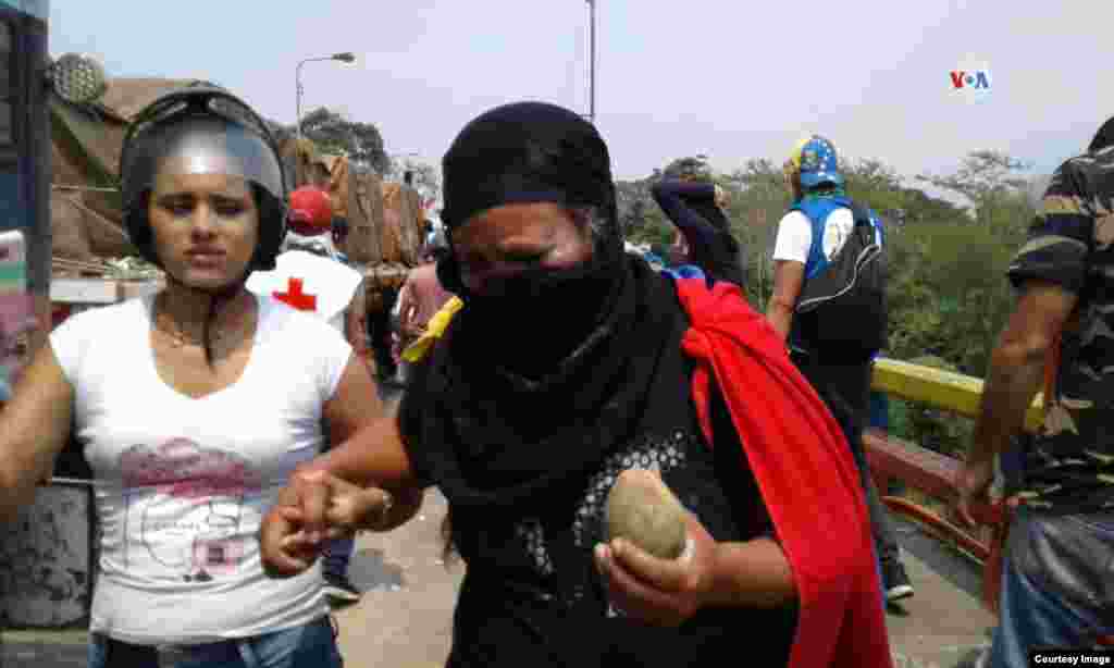 Una mujer sostiene una de las piedras que fueron utilizadas, por parte de los manifestantes en la frontera, en contra de la entrada de la ayuda humanitaria a Venezuela.
