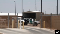 FILE - A Customs and Border Patrol officer guards the entrance to the Border Patrol station in Clint, Texas.