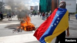 FILE - Protesters clash with riot police during a rally to demand a referendum to remove Venezuela's President Nicolas Maduro in Caracas, Venezuela.