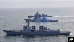 Kapal perusak AL Korea Selatan Yulgok Yi I, bawah, kapal perusak berpeluru kendali AL AS USS Benfold dan kapal perusak Pasukan Bela Diri Maritim Jepang Atago, dalam latihan pertahanan bersama di Semenanjung Korea, Senin 17 April 2023. (Foto: via AP)