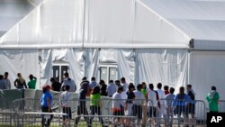 FILE - Children line up to enter a tent at the Homestead Temporary Shelter for Unaccompanied Children in Homestead, Florida, Feb. 19, 2019.