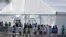 FILE - Children line up to enter a tent at the Homestead Temporary Shelter for Unaccompanied Children in Homestead, Florida, Feb. 19, 2019.