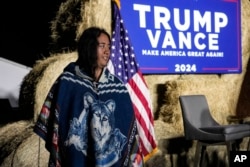 bigail Blue, a member of the Lumbee Tribe, walks by the stage during a campaign event in support of Republican presidential nominee former President Donald Trump, Oct. 18, 2024, in Red Springs, N.C. (AP Photo/David Yeazell)