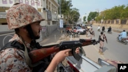 Pripadnik paravojnih snaga stražari pored puta, pred opšte izbore 8. februara, u Karačiju, u Pakistanu, 7. februara 2024. (Foto: AP/Fareed Khan)