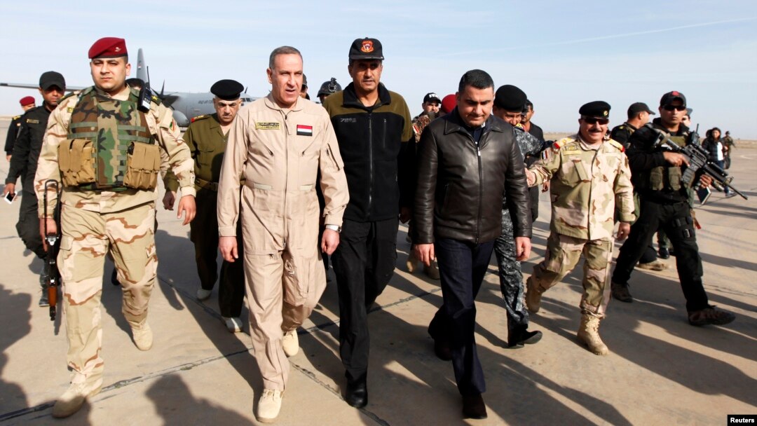 Iraq's Defence Minister Khaled al-Obeidi (2nd L) arrives at Base Speicher in the Iraqi city of Tikrit, Dec. 8, 2014. 