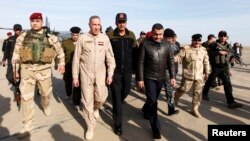 Iraq's Defence Minister Khaled al-Obeidi (2nd L) arrives at Base Speicher in the Iraqi city of Tikrit, Dec. 8, 2014. 