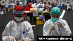 Petugas kesehatan menyiapkan vaksin COVID-19 Sinovac saat vaksinasi massal bagi tenaga medis di stadion Gelora Bung Karno, Jakarta. (Foto: REUTERS/Willy Kurniawan)